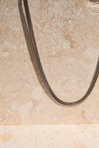 Sol & Aura - Medusa Necklace - close up of detailed herringbone chain hanging off stone surface