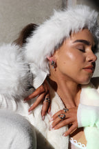 Sol & Aura - 'OH BABY' and 'RIPPLE' rings worn by woman in white with fur headband