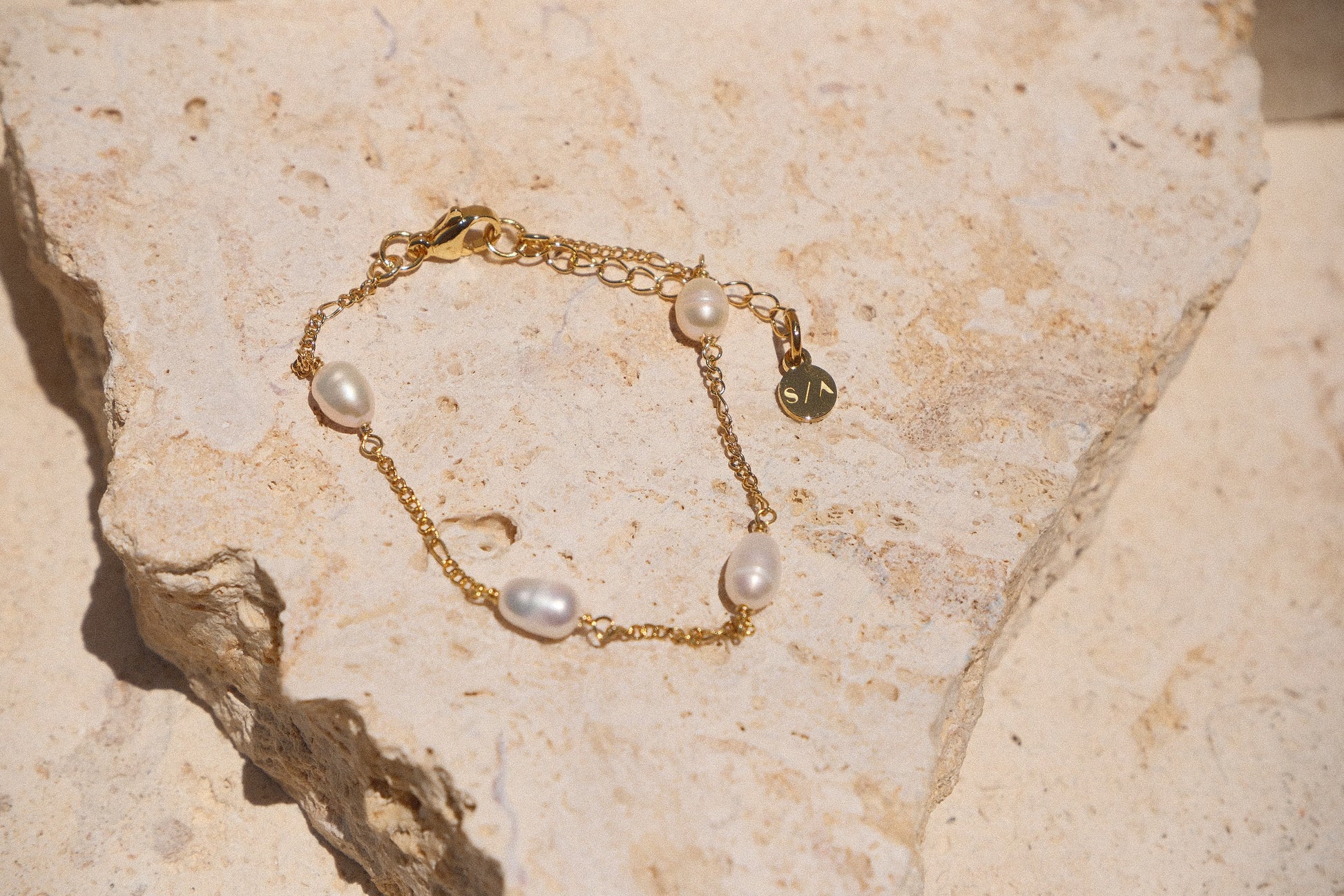 Sol & Aura - Pearla Bracelet - 4 natural pearls on bracelet on thin gold chain on stone surface