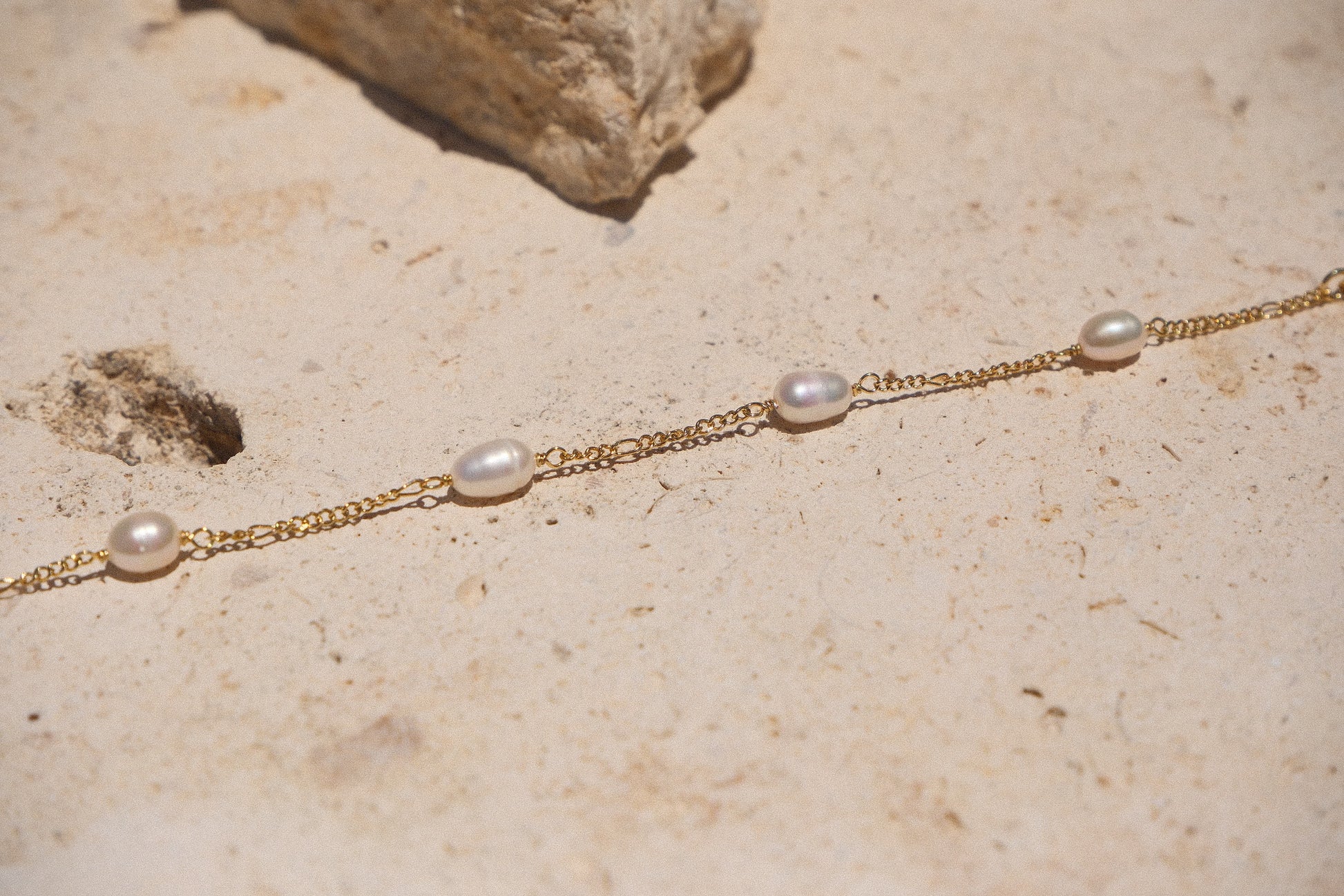 Sol & Aura - Pearla Bracelet - 4 natural pearls on bracelet on thin gold chain on stone surface