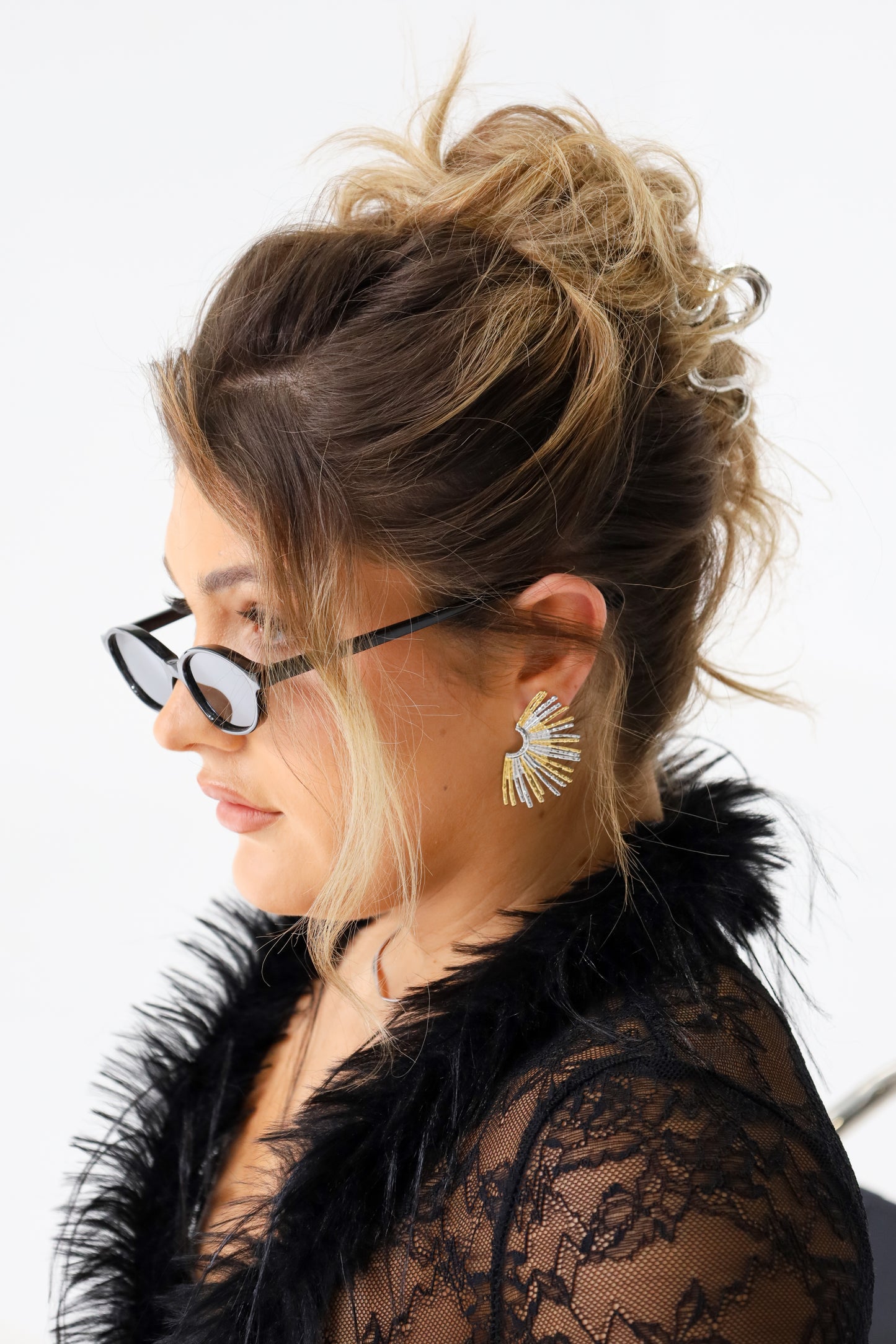 Sol & Aura - Woman in black lace and fur top wearing Ray earrings & Sicily sunglasses in black 