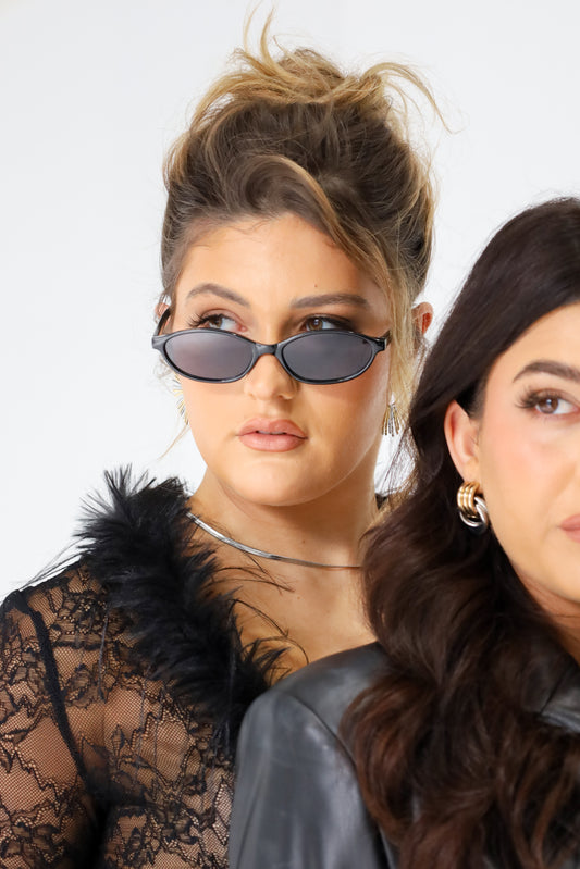 Sol & Aura - Sicily Sungalsses worn by woman in black lacey furry top and Medusa silver necklace, standing next to another woman with black hair