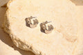 Sol & Aura - Silver hoop earrings on a textured stone surface