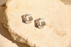 Sol & Aura - Silver hoop earrings on a textured stone surface