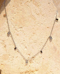 Sol & Aura - Silver necklace with square pendants on a textured stone 