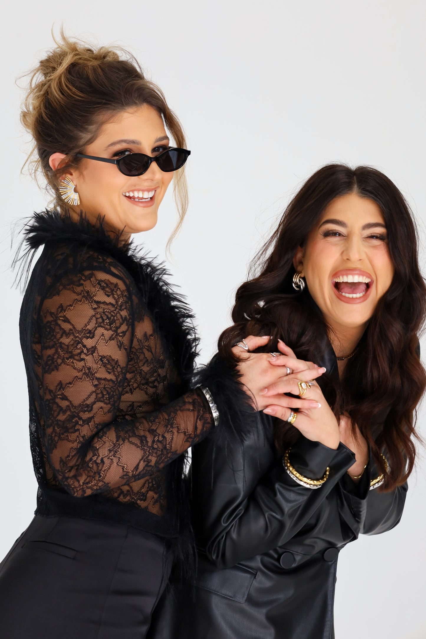 Sol & Aura - two women laughing wearing Sol & Aura jewellery and sunglasses holding hands 