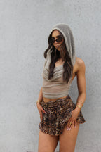 Sol & Aura - woman in mesh top and leopard prit skirt posing in Sol & Aura jewellery and sunglasses